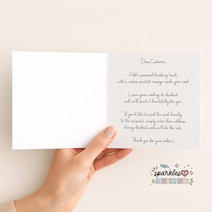 a hand holding a blank card with a personalized message written on it.