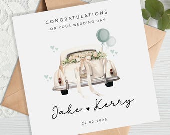 May include: A wedding card featuring a vintage car decorated with flowers and a ribbon. The card reads "Congratulations on your wedding day" and includes the names "Jake & Kerry" and the date "22.02.2025". Two balloons and small hearts are also included.