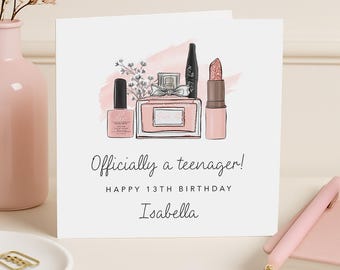 May include: A white greeting card with a watercolor illustration of beauty products, including nail polish, perfume, and lipstick. The card reads "Officially a teenager! Happy 13th Birthday Isabella."