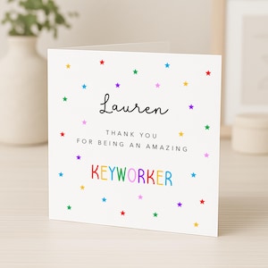 May include: A white ceramic mug with a black handle and the text "But First, Coffee" in a black, handwritten-style font. The mug is on a white surface.