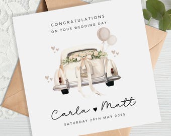 May include: A wedding card featuring a cream-colored vintage car decorated with flowers and a ribbon. The card reads "Congratulations on your wedding day" and includes the names "Carla & Matt" and the date "Saturday 29th May 2025". Two balloons float above the car.