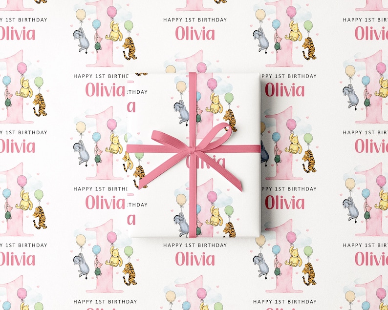 The image is a repeating pattern of a pink gift box with a bow, featuring illustrations of Winnie the Pooh and other characters, along with the text "Happy 1st Birthday Olivia" and "Happy 1st Birthday" written on it.