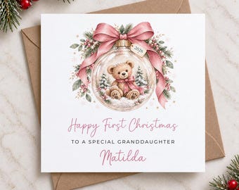Puede incluir: Una tarjeta de felicitación cuadrada con la ilustración de un adorno navideño transparente que contiene un osito de peluche, un lazo rosa y ramas de pino. El texto dice: Happy First Christmas TO A SPECIAL GRANDDAUGHTER Matilda, con una etiqueta de 2026.