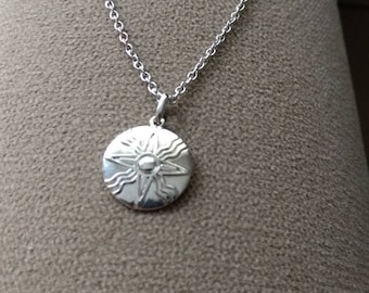 Sumerian sun disc pendant in rhodium-plated bronze with a stainless steel chain.