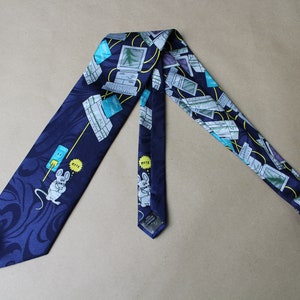 May include: Navy blue necktie with a repeating pattern of computers, keyboards, and a cartoon mouse with the word "BYTE". The tie has a dark blue floral design on the bottom.