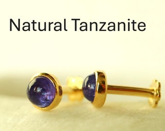 May include: A pair of gold stud earrings with a round, purple tanzanite gemstone in each setting. Natural Tanzanite.