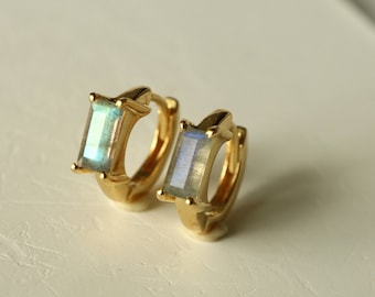 May include: A pair of gold hoop earrings with a rectangular iridescent gemstone in the center of each hoop.