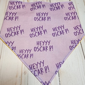 May include: Purple bandana with a yellow border and the text "Heyyy Oscar P!" repeated in a pattern.
