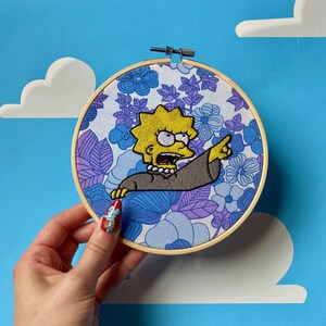 EL SISTEMA ESTÁ EQUIVOCADO - Arte mural con bastidor de bordado floral de Los Simpsons