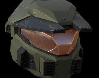 Könnte beinhalten: Ein grüner und schwarzer Helm mit einem orangefarbenen Visier. Der Helm hat eine strukturierte Oberfläche und verschiedene Details, darunter Lüftungsschlitze und einen erhöhten Kamm auf der Oberseite.