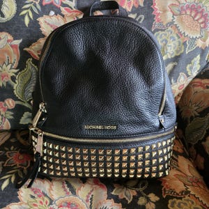 Mochila Michael Kors de piel negra con detalles en guijarros y herrajes dorados. Bolsos, mochilas, bolsos de diseñador, accesorios para mujer, bolsos de hombro estilo bohemio.