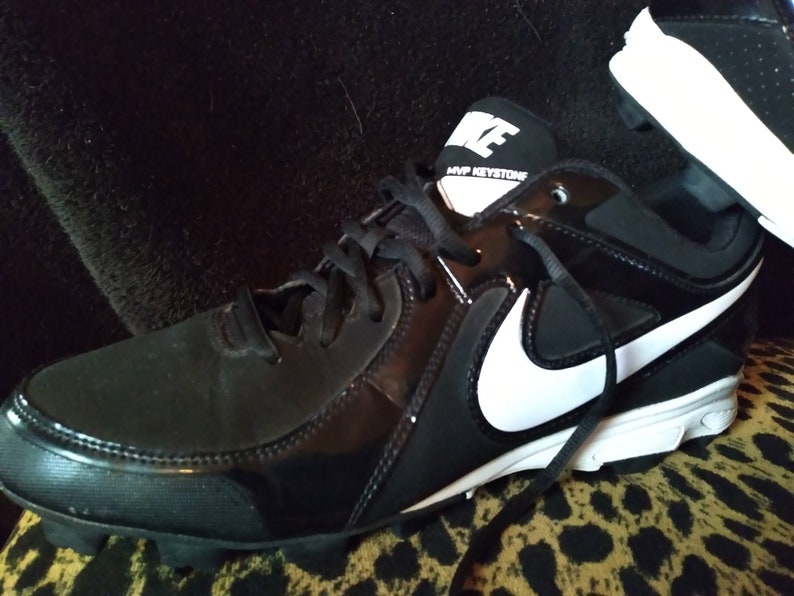 May include: Black and white baseball cleats with a white Nike swoosh and the text "MVP KEYSTONE" on the side.
