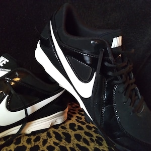 May include: A pair of black and white Nike baseball cleats with white accents and the text "MVP KEYSTONE" on one shoe.
