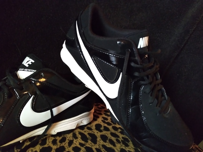 May include: A pair of black and white Nike baseball cleats with white accents and the text "MVP KEYSTONE" on one shoe.