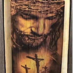 May include: A brown book with a detailed image of Jesus Christ on the cover. The image shows Jesus wearing a crown of thorns and a cross behind him.