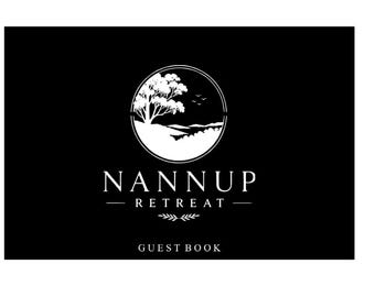 Könnte beinhalten: Ein schwarzes rechteckiges Gästebuch mit einem weißen kreisförmigen Logo, das einen Baum und eine Landschaft zeigt. Der Text NANNUP RETREAT ist in weißen Großbuchstaben unter dem Logo gedruckt, mit dem Wort GUEST BOOK unten in der Mitte.