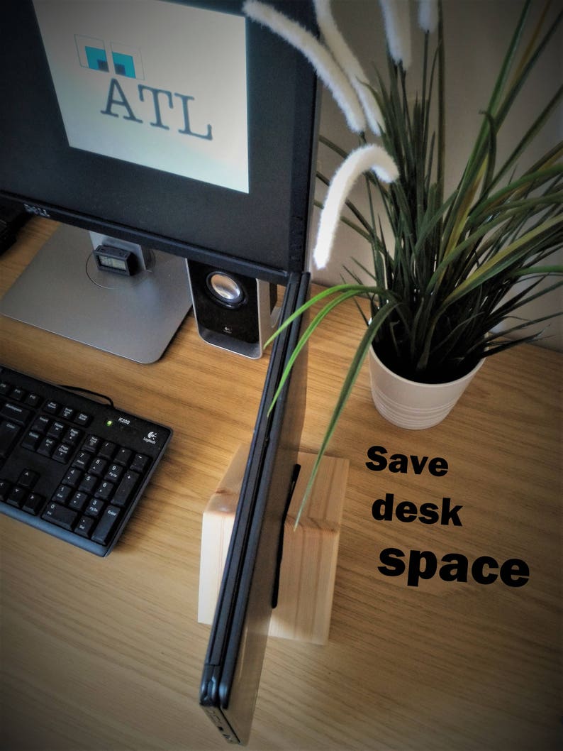 K&ouml;nnte beinhalten: Ein Laptopst&auml;nder aus Holz mit einem Laptop darauf. Der St&auml;nder steht auf einem Holztisch mit einer Tastatur, einem Computermonitor und einer Topfpflanze. Der Text "Save desk space" ist auf dem Tisch geschrieben.