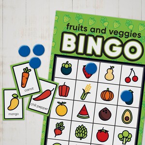 May include: A green and white bingo card with images of fruits and vegetables. The card has a free space in the centre and is labelled "fruits and veggies BINGO".