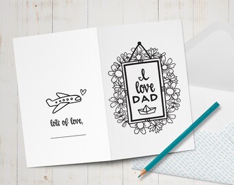May include: A blank card with a black and white illustration of a plane and the text "lots of love." The card is open to reveal a black and white illustration of a framed picture with the text "I love Dad" and a paper boat inside the frame. The frame is surrounded by a wreath of flowers.