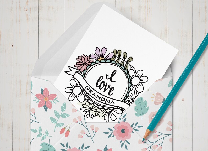 May include: A white card with a black and white floral wreath design. The wreath surrounds a circle with the text "I love Grandma".