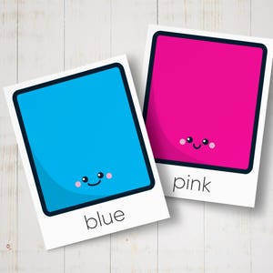 May include: Two colourful squares with happy faces. The blue square says "blue" and the pink square says "pink".