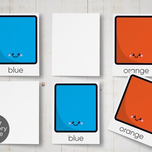 May include: A set of six cards for a memory game. The cards feature blue and orange squares with happy faces. The words "blue" and "orange" are printed below each square.