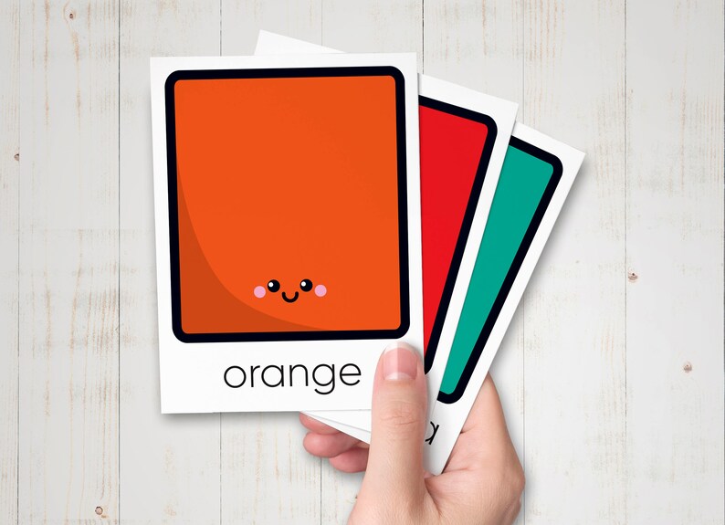 May include: Three cards with a square shape and a happy face on each. The first card is orange and says "orange" at the bottom. The second card is red and the third card is teal.