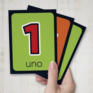 May include: Green and black flash cards with a red number 1 and the word "uno" on the front.