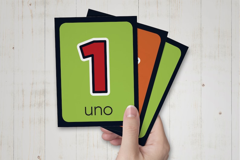 May include: Green and black flash cards with a red number 1 and the word "uno" on the front.