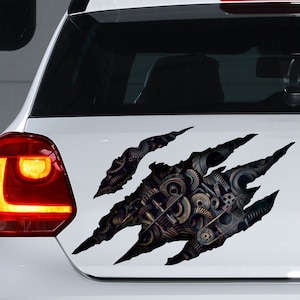 Puede incluir: Una calcomanía para coche en blanco y negro que presenta una marca de garra con un diseño detallado de engranajes y piñones dentro de la garra.