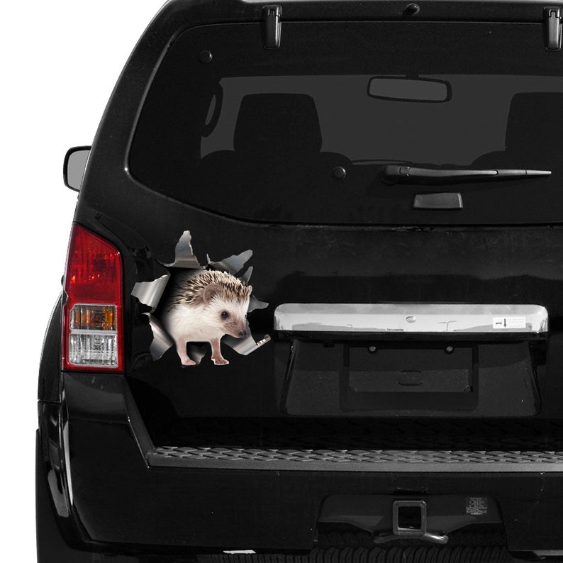 May include: A black SUV featuring a decorative sticker of a hedgehog emerging from a torn metal effect. The hedgehog is brown and white. The sticker creates a 3D illusion, giving the impression of the animal breaking through.