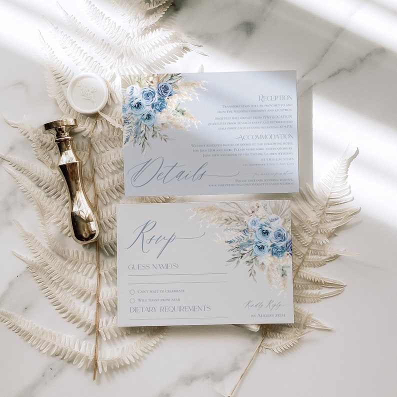 May include: Blue and white wedding invitation with a floral design. The invitation includes details about the reception, accommodation, and RSVP information. The RSVP card includes a section for guest names, dietary requirements, and a choice of "Can't wait to celebrate" or "Will toast from afar".