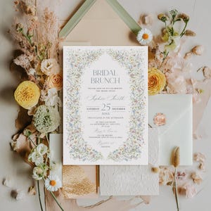 May include: A white invitation with a floral border. The text reads "Bridal Brunch" and includes the bride-to-be's name, Sophie Smith, the date, Saturday, December 25, 20XX, and the time, two o'clock in the afternoon. The invitation also includes the RSVP information, "RSVP on or before November 15th at 7:0000 at Amazon."