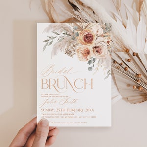 May include: A white rectangular invitation card featuring a watercolor floral arrangement of roses and pampas grass at the top. The text reads Bridal Brunch, Please join us in honor of the bride-to-be Julia Smith, Sunday, 25th February 20XX.