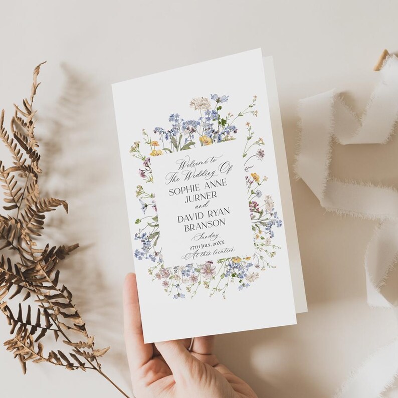 May include: A wedding ceremony program with a floral border. The text reads "Welcome to the Wedding of Sophie Anne Jurner and David Ryan Branson, Sunday, 27th July, 20XX, At this location."