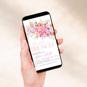 May include: A smartphone screen displaying a digital invitation for a Bridal Brunch. The design features a watercolor floral arrangement in pink, orange, and purple hues at the top, with text including Bridal Brunch, Sophie Smith, and event details.