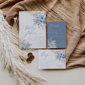 K&ouml;nnte beinhalten: Hochzeits-Einladungssuite mit einem blauen und wei&szlig;en Blumenmuster. Die Einladungskarte zeigt die Namen "Ashley + Jason" und das Hochzeitsdatum. Die Detailkarte enth&auml;lt Informationen &uuml;ber den Transport, den Veranstaltungsort und die Unterk&uuml;nfte. Die RSVP-Karte bietet einen Platz f&uuml;r G&auml;ste, um ihre Teilnahme und besondere Ern&auml;hrungsw&uuml;nsche anzugeben.