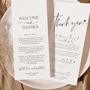 Può includere: Due cartoncini rettangolari bianchi per matrimonio con testo nero. Il cartoncino a sinistra riporta Welcome and Thanks, seguito da un messaggio per gli ospiti e i nomi Sophie e David. Il cartoncino a destra riporta Thank you, un messaggio e Olivia e Robin.