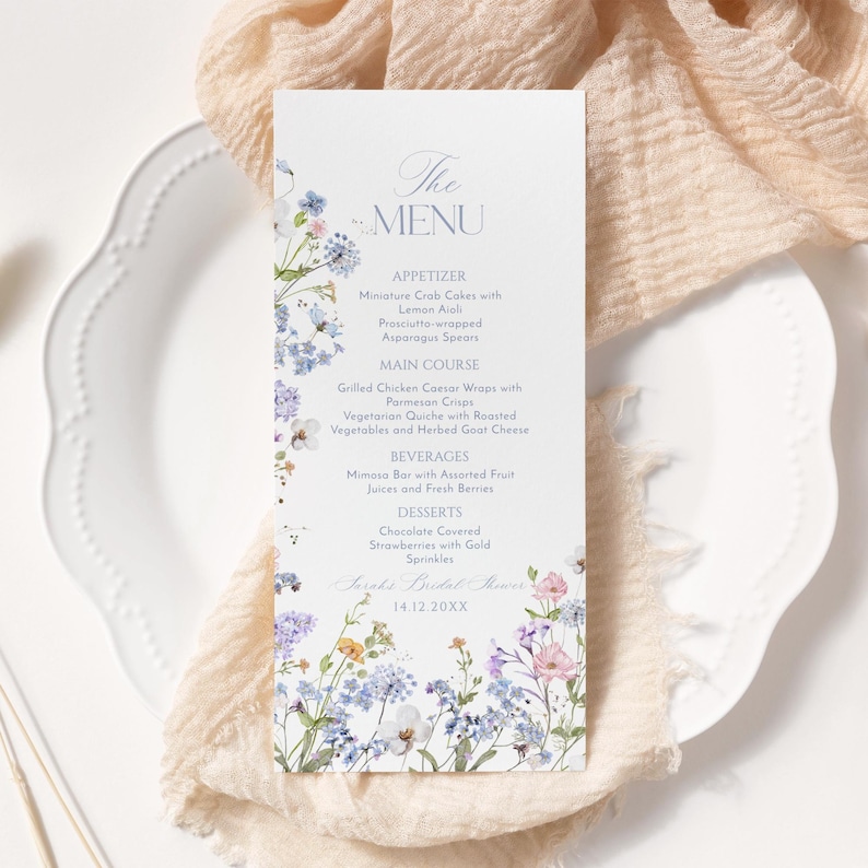 K&ouml;nnte beinhalten: Eine Hochzeitsmen&uuml;karte mit einem floralen Design mit blauen, violetten und rosa Blumen. Das Men&uuml; umfasst Vorspeisen, Hauptgericht, Getr&auml;nke und Desserts. Der Text auf der Karte lautet "The Menu" und "Sarah's Bridal Shower 14.12.20XX".