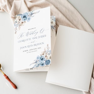 May include: A white wedding program with blue floral designs. The text reads "Welcome to The Wedding of Charlotte Anne Jurner and Jason Ryan Branson Sunday, 24th June 20XX At This Location."