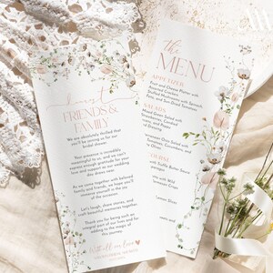 May include: Two white paper cards featuring floral illustrations in soft pink and green tones. One card is titled Dearest Friends & Family, and the other is titled The Menu, listing appetizers, salads, and main courses in elegant typography.