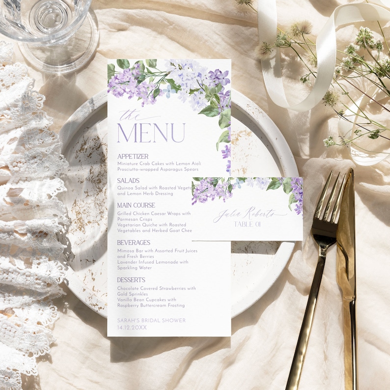 Op de afbeelding: Een lila menukaart met een bloemenontwerp voor een bruidsdouche met de tekst "the MENU" bovenaan. Het menu bevat voorgerechten, salades, hoofdgerecht, dranken en desserts. Onderaan de kaart staat "SARAH'S BRIDAL SHOWER 14.12.20XX".