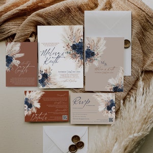 K&ouml;nnte beinhalten: Ein Satz Hochzeitseinladungskarten im rustikalen Stil. Die Karten zeigen ein florales Design mit Pampasgras und blauen Blumen. Der Text auf den Karten enth&auml;lt die Namen "Melisa & Keith" und das Datum "Samstag, 24. September 20XX".