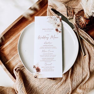 May include: A rectangular wedding menu card printed on white paper with floral illustrations in shades of brown and cream. The text includes names Jessica & Richard, date 09.21.20XX, and sections for Appetizer, Main Course, and Dessert.