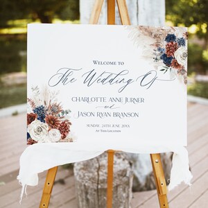 May include: Welcome to The Wedding Of Charlotte Anne Jurner and Jason Ryan Branson, Sunday, 24th June 20XX, at this location. A white sign with blue and red floral design.