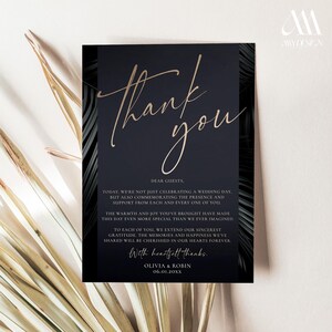 K&ouml;nnte beinhalten: Eine rechteckige Hochzeits-Dankeskarte mit dunkelblauem Hintergrund und goldenem Schreibschrifttext Thank you. Die Karte zeigt schwarze Palmenblattmuster an den Seiten und enth&auml;lt gedruckten Text, der den G&auml;sten dankt, unterzeichnet von Olivia und Robin mit dem Datum 06.01.20XX.