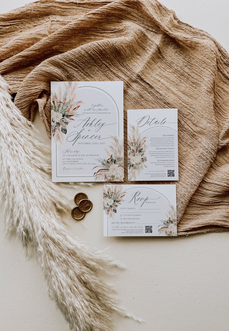 Puede incluir: Un juego de invitaciones de boda compuesto por tres tarjetas blancas con marcos arqueados, ilustraciones de hierba de la pampa y texto en caligraf&iacute;a negra. El set incluye una invitaci&oacute;n para Ashley y Spencer, una tarjeta de detalles, una tarjeta RSVP y tres sellos de cera dorados.