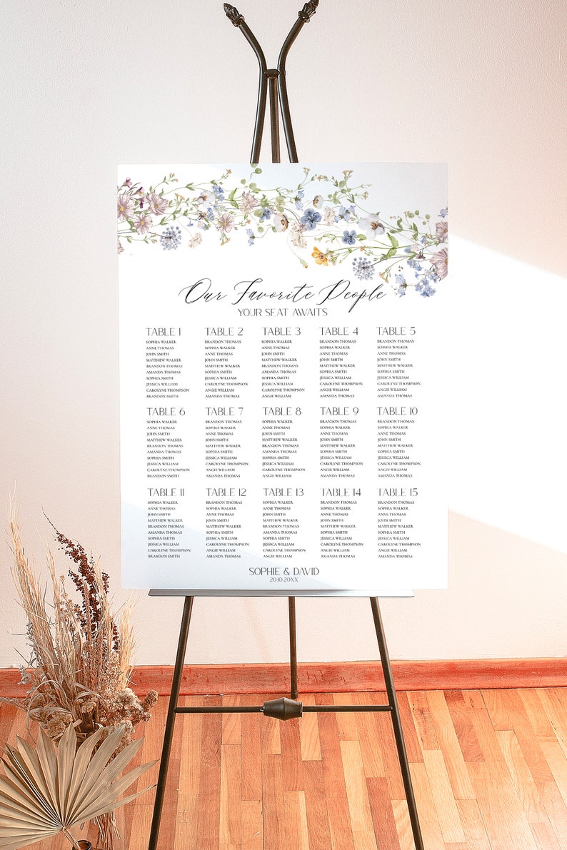 May include: A floral wedding seating chart with the title "Our Favorite People" and the names of guests listed by table number. The chart is printed on white paper and features a watercolor floral design.