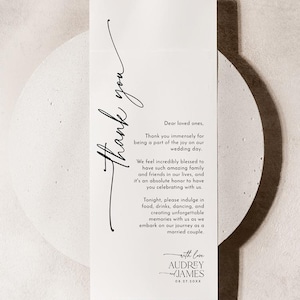 May include: A white wedding thank you card with elegant black script. The card reads "thank you" in a flowing font, followed by a message of gratitude and the names Audrey and James with a date.