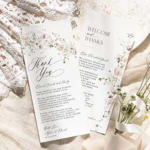 May include: Two white wedding program cards featuring delicate watercolor floral illustrations in soft pink and green tones. The text includes "Thank You," "Welcome and Thanks," and "Dear Cherished Guests," with elegant black typography printed on textured paper.